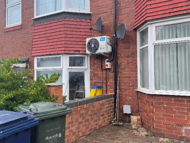 Outdoor air conditioning unit fitted to the side of a red-brick house, the kind of property common in Middlesbrough