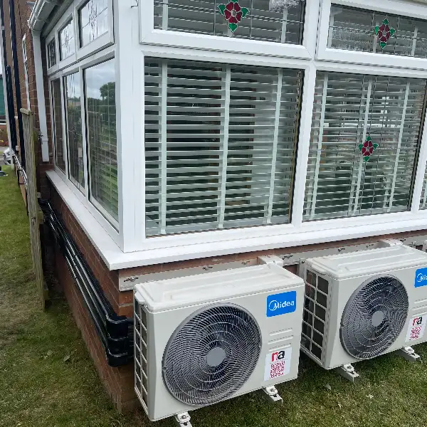 Row of outdoor air conditioning units installed alongside a conservatory