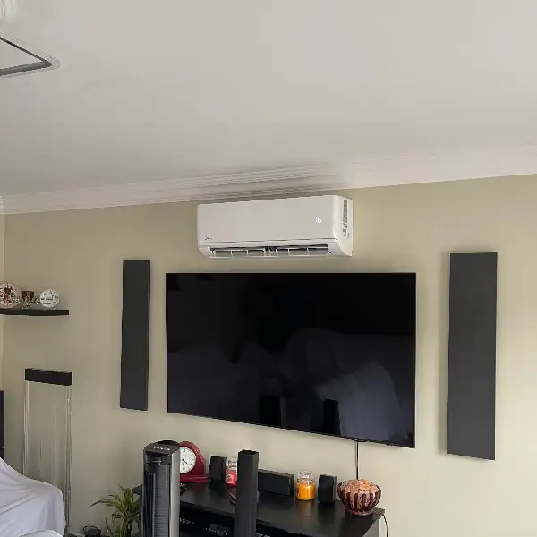Living room air conditioning unit installed above a wall-mounted television