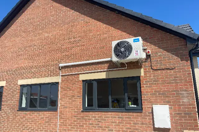 Split system outdoor unit mounted high on the wall of a brick building